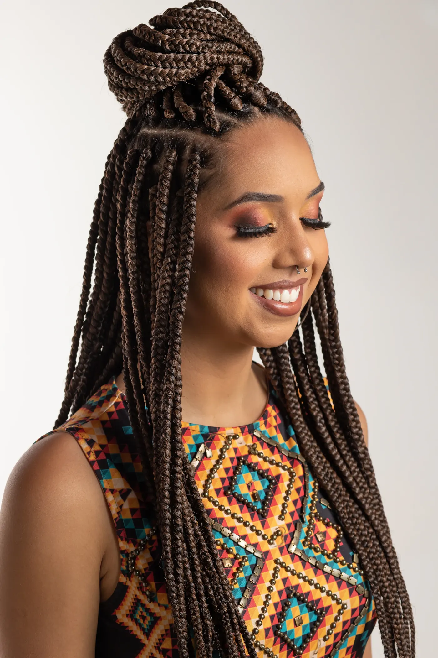 Waist-length box braids, styled and beaded
